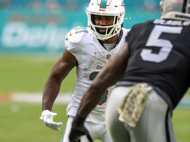 Miami Dolphins running back Raheem Mostert (31) runs towards Las Vegas Raiders linebacker Divine Deablo (5) during the first half of an NFL football game, Sunday, Nov. 19, 2023, in Miami Gardens, Fla. (AP Photo/Michael Laughlin)