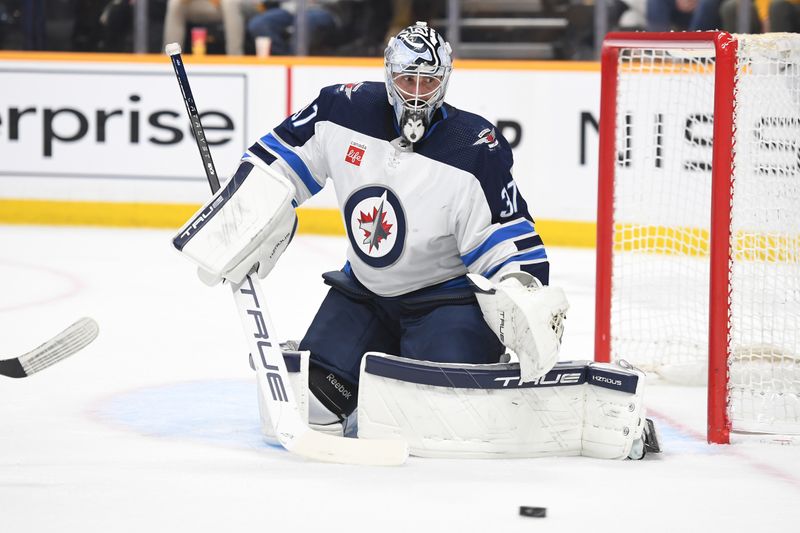 Apr 9, 2024; Nashville, Tennessee, USA; Winnipeg Jets goaltender Connor Hellebuyck (37) watches the puck into the corner after a save during the first period against the Nashville Predators at Bridgestone Arena. Mandatory Credit: Christopher Hanewinckel-USA TODAY Sports