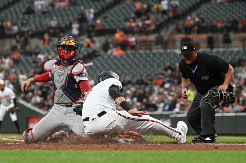 May 29, 2024; Baltimore, Maryland, USA; Baltimore Orioles outfielder Colton Cowser (17)   slides to score before Boston Red Sox catcher Connor Wong (12) can apply a tag during the second inning  at Oriole Park at Camden Yards. Mandatory Credit: Tommy Gilligan-USA TODAY Sports