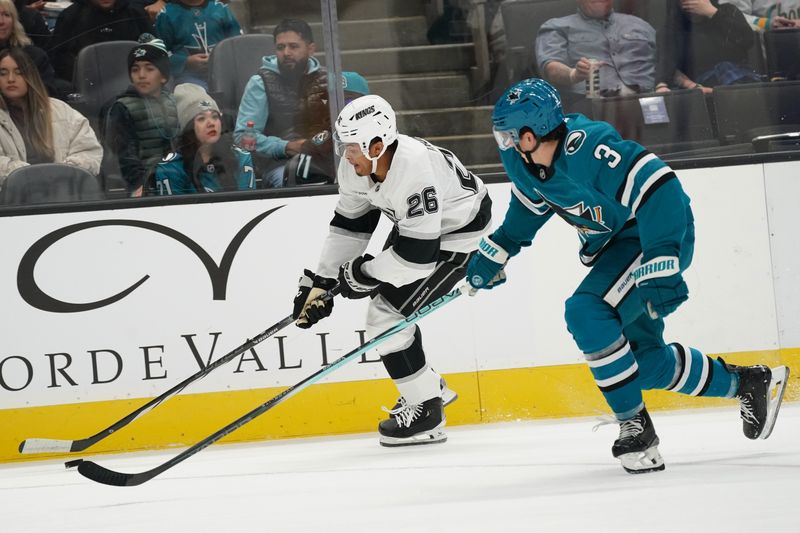 Nov 25, 2024; San Jose, California, USA; Los Angeles Kings center Akil Thomas (26) advances the puck against San Jose Sharks defenseman Henry Thrun (3) in the first period at SAP Center at San Jose. Mandatory Credit: David Gonzales-Imagn Images