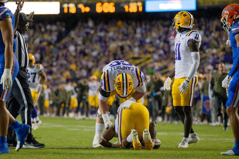 Nov 11, 2023; Baton Rouge, Louisiana, USA;  LSU Tigers running back John Emery Jr. (4) is injured as he rushes against Florida Gators defensive end T.J. Searcy (19) during the first half at Tiger Stadium. Mandatory Credit: Stephen Lew-USA TODAY Sports