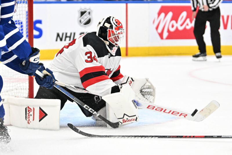 Apr 11, 2024; Toronto, Ontario, CAN; New Jersey Devils goalie Jake Allen (34) makes a save against the Toronto Maple Leafs in the third period at Scotiabank Arena. Mandatory Credit: Dan Hamilton-USA TODAY Sports