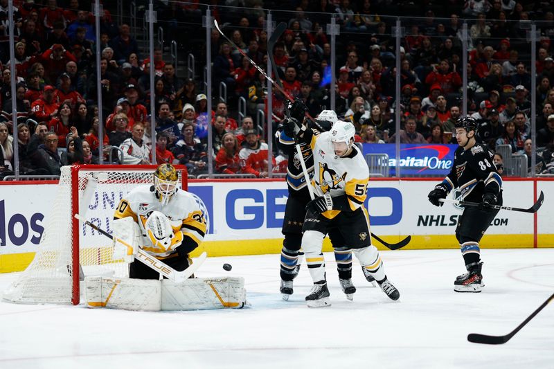 Jan 18, 2025; Washington, District of Columbia, USA; Pittsburgh Penguins goaltender Joel Blomqvist (30) makes a save in front ofWashington Capitals center Nic Dowd (26) and Penguins defenseman Kris Letang (58) in the first period at Capital One Arena. Mandatory Credit: Geoff Burke-Imagn Images