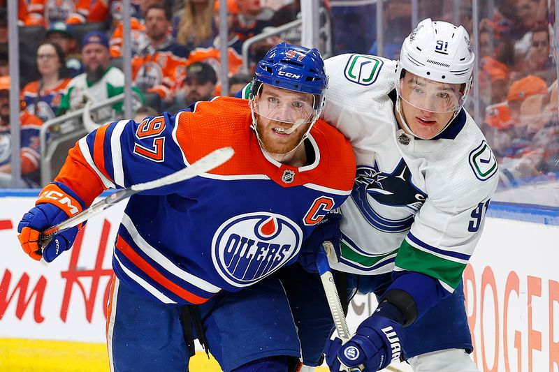 May 14, 2024; Edmonton, Alberta, CAN; Edmonton Oilers forward Connor McDavid (97) and Vancouver Canucks defensemen Nikita Zadorov (91) battle for position during the third period in game four of the second round of the 2024 Stanley Cup Playoffs at Rogers Place. Mandatory Credit: Perry Nelson-USA TODAY Sports