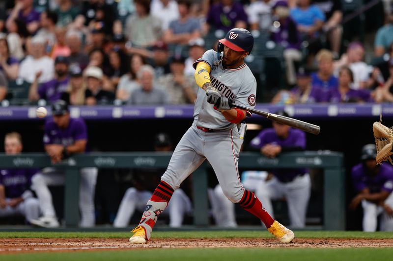 Jun 21, 2024; Denver, Colorado, USA; Washington Nationals designated hitter Eddie Rosario (8) hits a sacrifice fly RBI in the fourth inning against the Colorado Rockies at Coors Field. Mandatory Credit: Isaiah J. Downing-USA TODAY Sports