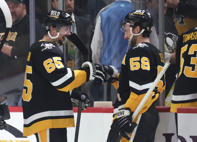 Mar 11, 2025; Pittsburgh, Pennsylvania, USA;  Pittsburgh Penguins defenseman Erik Karlsson (65) celebrates scoring the game winning goal in overtime with defenseman Kris Letang (58) after defeating the Vegas Golden Knights at PPG Paints Arena. Mandatory Credit: Charles LeClaire-Imagn Images