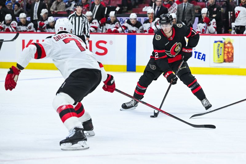 Jan 31, 2026; Ottawa, Ontario, CAN; Ottawa Senators center Shane Pinto (12) plays the puck against New Jersey Devils defenseman Jonas Siegenthaler (71) during the third period at Canadian Tire Centre. Mandatory Credit: David Kirouac-Imagn Images