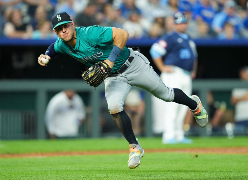 Jun 7, 2024; Kansas City, Missouri, USA; Seattle Mariners shortstop Dylan Moore (25) throws to first base during the fifth inning against the Kansas City Royals at Kauffman Stadium. Mandatory Credit: Jay Biggerstaff-USA TODAY Sports