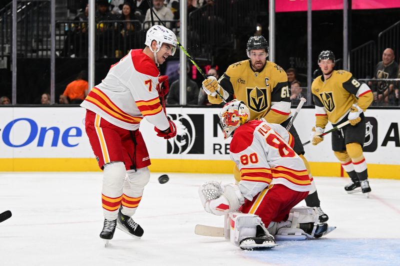 Oct 28, 2024; Las Vegas, Nevada, USA; Calgary Flames goaltender Dan Vladar (80) stops a shot near defenseman Kevin Bahl (7) against the Vegas Golden Knights in the second period at T-Mobile Arena. Mandatory Credit: Candice Ward-Imagn Images