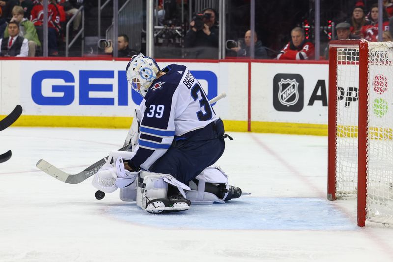 Mar 21, 2024; Newark, New Jersey, USA; Winnipeg Jets goaltender Laurent Brossoit (39) makes a save against the New Jersey Devils during the second period at Prudential Center. Mandatory Credit: Ed Mulholland-USA TODAY Sports