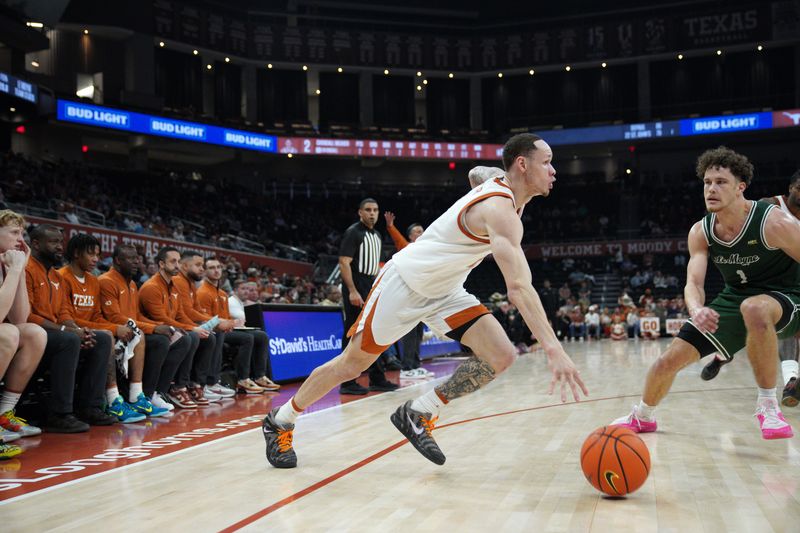 Dec 16, 2025; Austin, Texas, USA; Texas Longhorns guard Chendall Weaver (2) dribbles against Le Moyne Dolphins guard Tennessee Rainwater (1) during the second half at Moody Center. Mandatory Credit: Dustin Safranek-Imagn Images