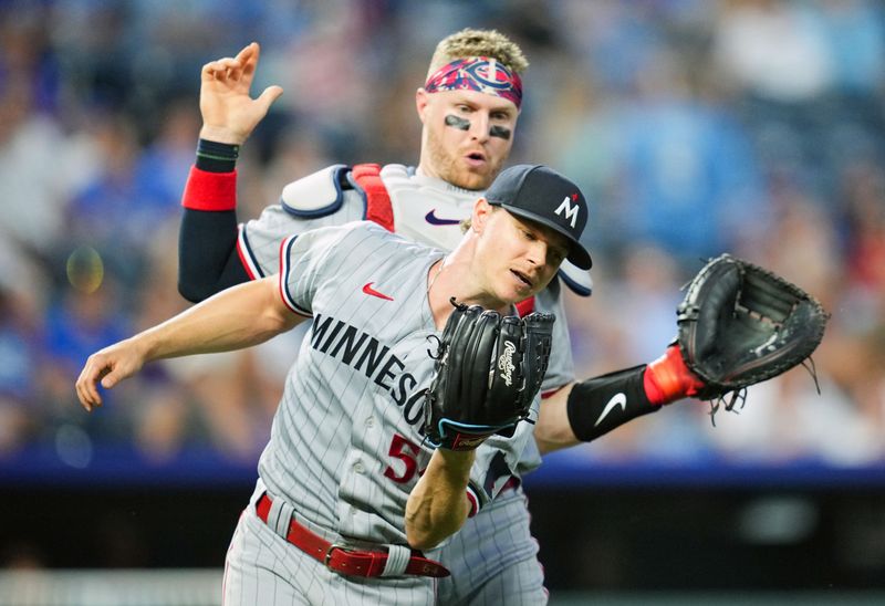 Jul 28, 2023; Kansas City, Missouri, USA; Minnesota Twins starting pitcher Sonny Gray (54) nearly collides with catcher Ryan Jeffers (27) as he catches a fly ball during the fifth inning against the Kansas City Royals at Kauffman Stadium. Mandatory Credit: Jay Biggerstaff-USA TODAY Sports