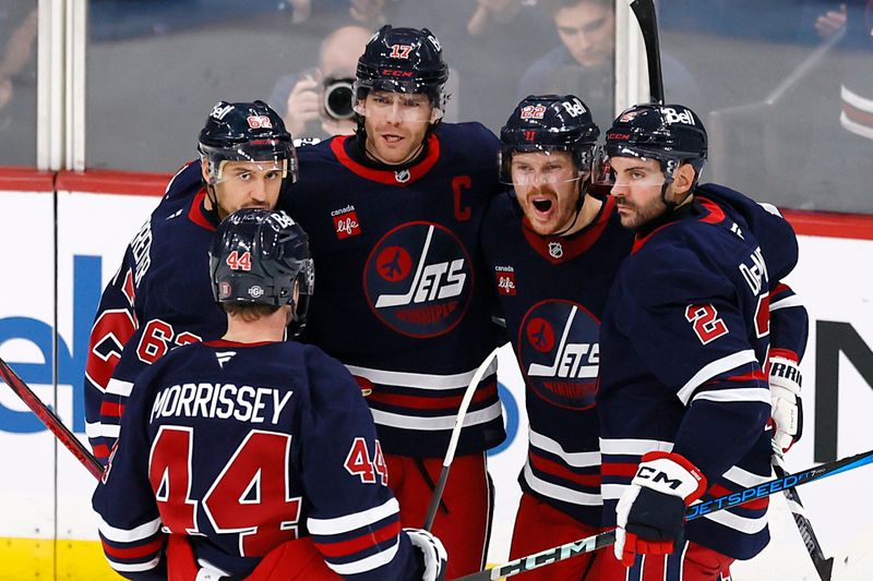 Oct 20, 2024; Winnipeg, Manitoba, CAN; Winnipeg Jets center Adam Lowry (17) celebrates his third period with his teammates against the Pittsburgh Penguins at Canada Life Centre. Mandatory Credit: James Carey Lauder-Imagn Images