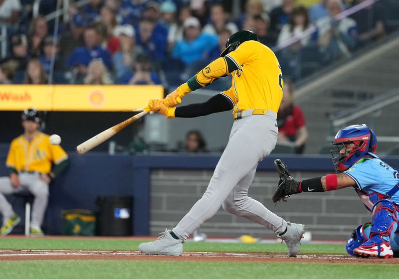 May 31, 2025; Toronto, Ontario, CAN; Athletics designated hitter Brent Rooker (25) hits a single against the Toronto Blue Jays during the first inning at Rogers Centre. Mandatory Credit: Nick Turchiaro-Imagn Images