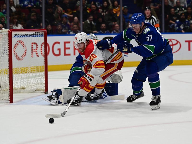 Mar 23, 2024; Vancouver, British Columbia, CAN; Vancouver Canucks defenseman Tyler Myers (57) checks Calgary Flames forward Blake Coleman (20) during the second period at Rogers Arena. Mandatory Credit: Simon Fearn-USA TODAY Sports