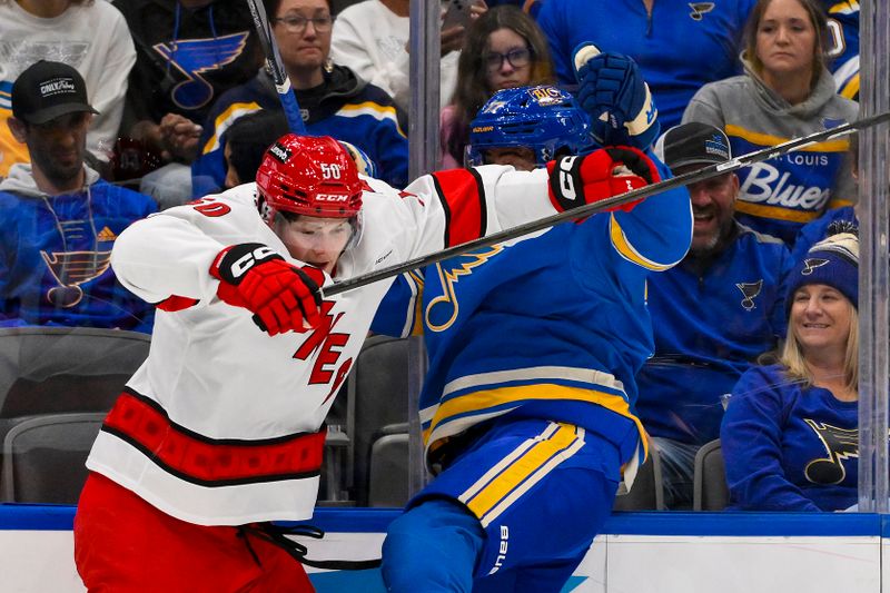Oct 19, 2024; St. Louis, Missouri, USA;  Carolina Hurricanes left wing Eric Robinson (50) checks St. Louis Blues defenseman Pierre-Olivier Joseph (77) during the first period at Enterprise Center. Mandatory Credit: Jeff Curry-Imagn Images