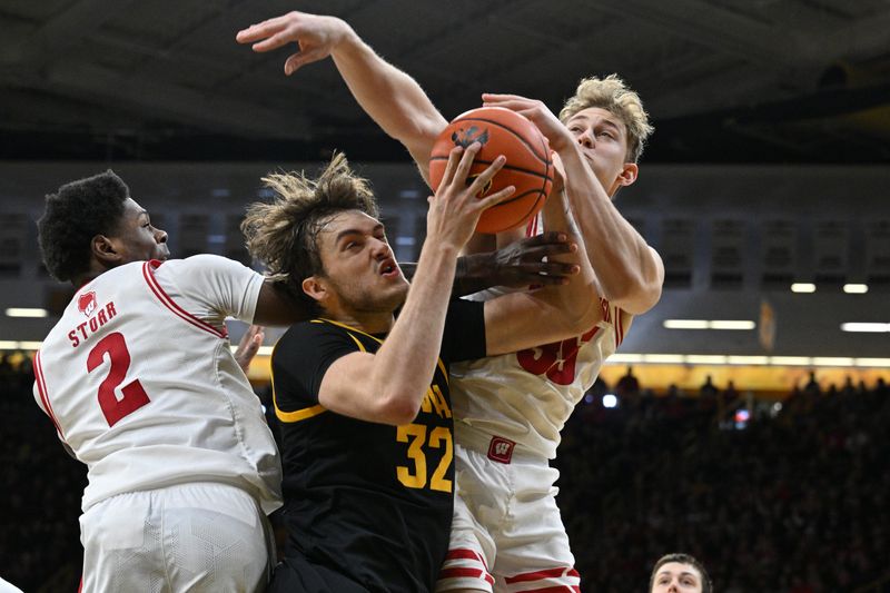 Feb 17, 2024; Iowa City, Iowa, USA; Iowa Hawkeyes forward Owen Freeman (32) battles for a rebound with Wisconsin Badgers guard AJ Storr (2) and forward Markus Ilver (35) during the second half at Carver-Hawkeye Arena. Mandatory Credit: Jeffrey Becker-USA TODAY Sports