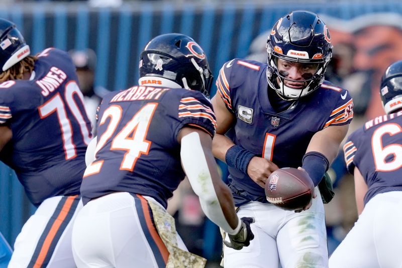 Chicago Bears quarterback Justin Fields hands off to running back Khalil Herbert during an NFL football game against the Detroit Lions Sunday, Nov. 13, 2022, in Chicago. (AP Photo/Charles Rex Arbogast)