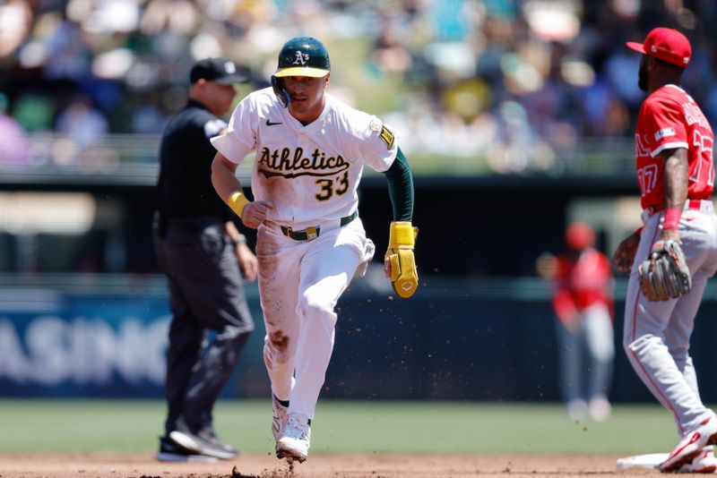 May 22, 2025; West Sacramento, California, USA; Athletics center fielder JJ Bleday (33) advances to third on a failed pick off attempt by Los Angeles Angels starting pitcher Tyler Anderson (31) during the third inning at Sutter Health Park. Mandatory Credit: Sergio Estrada-Imagn Images