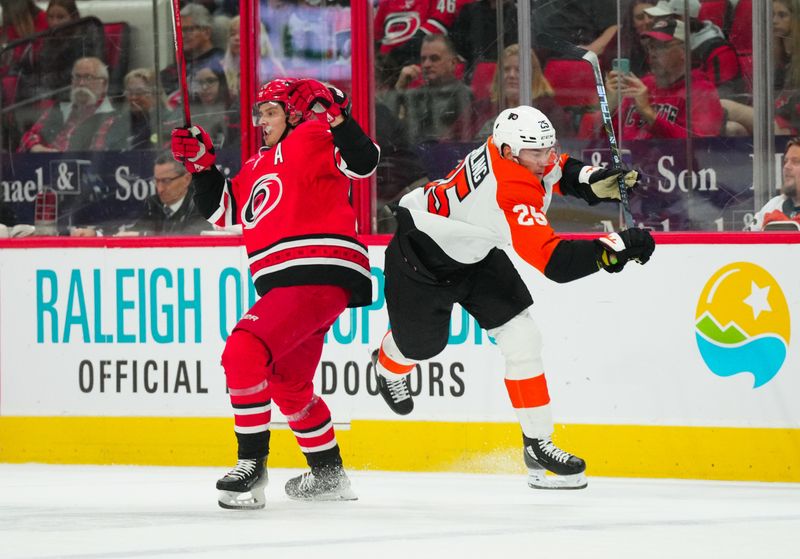 Mar 21, 2024; Raleigh, North Carolina, USA; Carolina Hurricanes center Sebastian Aho (20) checks Philadelphia Flyers center Ryan Poehling (25) during the first period at PNC Arena. Mandatory Credit: James Guillory-USA TODAY Sports