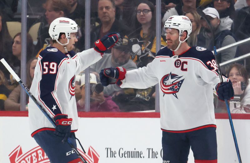 Mar 21, 2025; Pittsburgh, Pennsylvania, USA;  Columbus Blue Jackets right wing Yegor Chinakhov (59) congratulates center Boone Jenner (38) on his goal against the Pittsburgh Penguins during the first period at PPG Paints Arena. Mandatory Credit: Charles LeClaire-Imagn Images