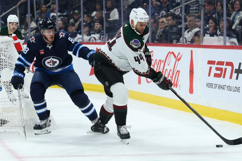 Jan 15, 2023; Winnipeg, Manitoba, CAN;  Arizona Coyotes forward Zack Kassian (44) shields the puck away from Winnipeg Jets defenseman Nate Schmidt (88) during the first period at Canada Life Centre. Mandatory Credit: Terrence Lee-USA TODAY Sports