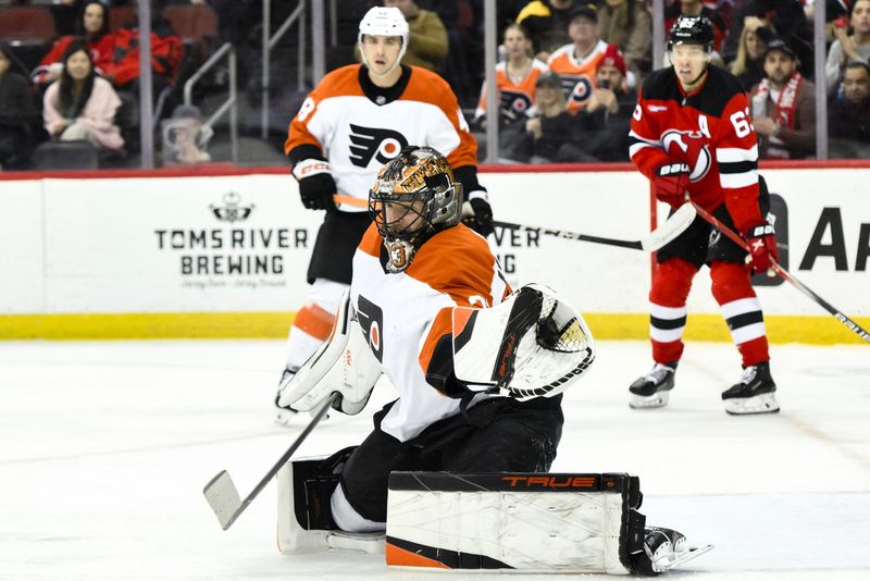 Jan 29, 2025; Newark, New Jersey, USA; Philadelphia Flyers goaltender Samuel Ersson (33) makes a glove save against the New Jersey Devils during the first period at Prudential Center. Mandatory Credit: John Jones-Imagn Images