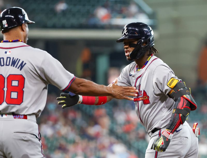 Apr 17, 2024; Houston, Texas, USA; Atlanta Braves first base coach Tom Goodwin (88) celebrates right fielder Ronald Acuna Jr. (13) single against the Houston Astros in the first inning at Minute Maid Park. Mandatory Credit: Thomas Shea-USA TODAY Sports