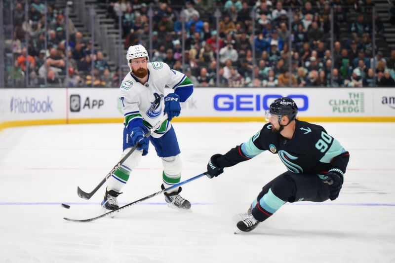 Feb 22, 2024; Seattle, Washington, USA; Vancouver Canucks defenseman Filip Hronek (17) passes the puck past Seattle Kraken left wing Tomas Tatar (90) during the first period at Climate Pledge Arena. Mandatory Credit: Steven Bisig-USA TODAY Sports