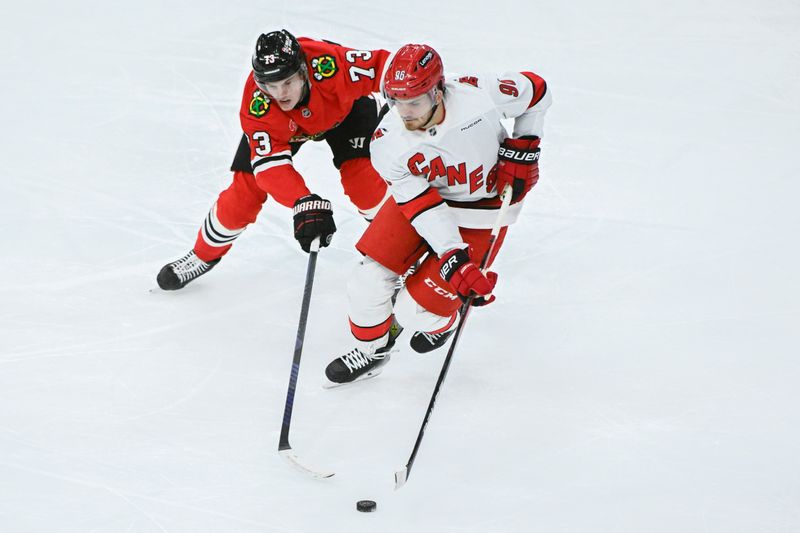 Jan 20, 2025; Chicago, Illinois, USA;  Carolina Hurricanes center Jack Roslovic (96) and Chicago Blackhawks left wing Lukas Reichel (73) chase the puck during the second period at the United Center. Mandatory Credit: Matt Marton-Imagn Images


