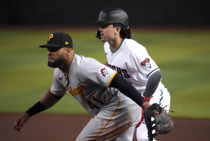 Jul 8, 2023; Phoenix, Arizona, USA; Arizona Diamondbacks left fielder Corbin Carroll (7) leads off first base as Pittsburgh Pirates first baseman Carlos Santana (41) covers the bag during the fourth inning at Chase Field. Mandatory Credit: Joe Camporeale-USA TODAY Sports