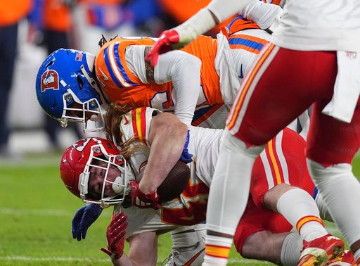 Denver Broncos safety Devon Key, top, tackles Kansas City Chiefs running back Carson Steele after a short gain in the second half of an NFL football game Sunday, Jan. 5, 2025, in Denver. (AP Photo/David Zalubowski)