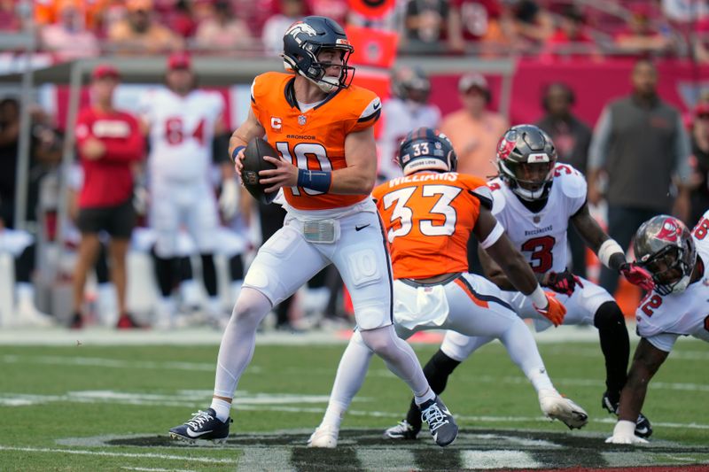 Denver Broncos quarterback Bo Nix (10) looks for a receiver during the first half of an NFL football game against the Tampa Bay Buccaneers, in Tampa, Fla. on Sunday, Sept. 22, 2024. (AP Photo/Chris O'Meara)