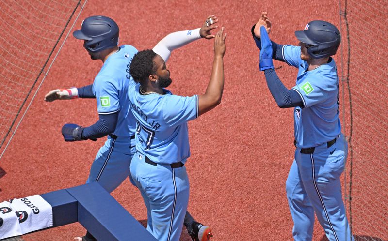 Jul 4, 2024; Toronto, Ontario, CAN; Toronto Blue Jays right fielder George Springer (4) and catcher Danny Jansen (, right) are greeted by first baseman Vladimir Guerrero Jr. (27) after scoring against the Houston Astros in the first inning at Rogers Centre. Mandatory Credit: Dan Hamilton-USA TODAY Sports