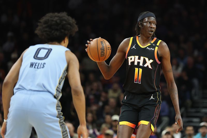 PHOENIX, ARIZONA - FEBRUARY 11: Bol Bol #11 of the Phoenix Suns handles the ball against Jaylen Wells #0 of the Memphis Grizzlies during the first half of the NBA game at Footprint Center on February 11, 2025 in Phoenix, Arizona.  NOTE TO USER: User expressly acknowledges and agrees that, by downloading and or using this photograph, User is consenting to the terms and conditions of the Getty Images License Agreement.  (Photo by Christian Petersen/Getty Images)