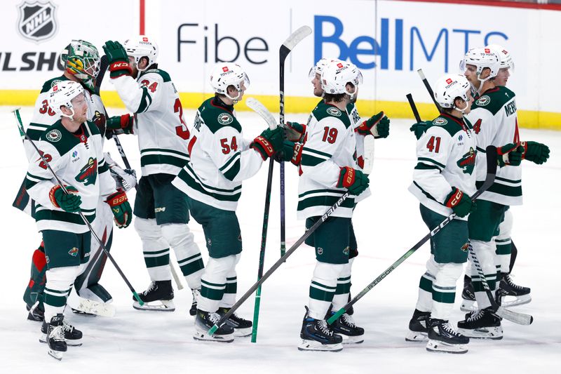 Sep 21, 2024; Winnipeg, Manitoba, CAN; Minnesota Wild players celebrate their victory over the Winnipeg Jets at Canada Life Centre. Mandatory Credit: James Carey Lauder-Imagn Images