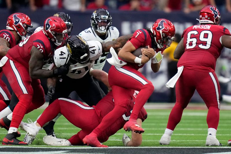 Houston Texans quarterback C.J. Stroud (7) works to escape a sack attempt by Jacksonville Jaguars linebacker Josh Allen (41) in the second half of an NFL football game in Houston, Sunday, Nov. 26, 2023. (AP Photo/Eric Christian Smith)