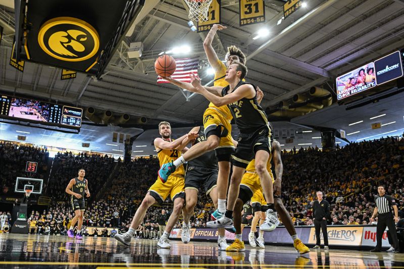 Jan 20, 2024; Iowa City, Iowa, USA; Purdue Boilermakers guard Fletcher Loyer (2) goes to the basket as Iowa Hawkeyes forward Owen Freeman (32) and forward Ben Krikke (23) defend during the first half at Carver-Hawkeye Arena. Mandatory Credit: Jeffrey Becker-USA TODAY Sports