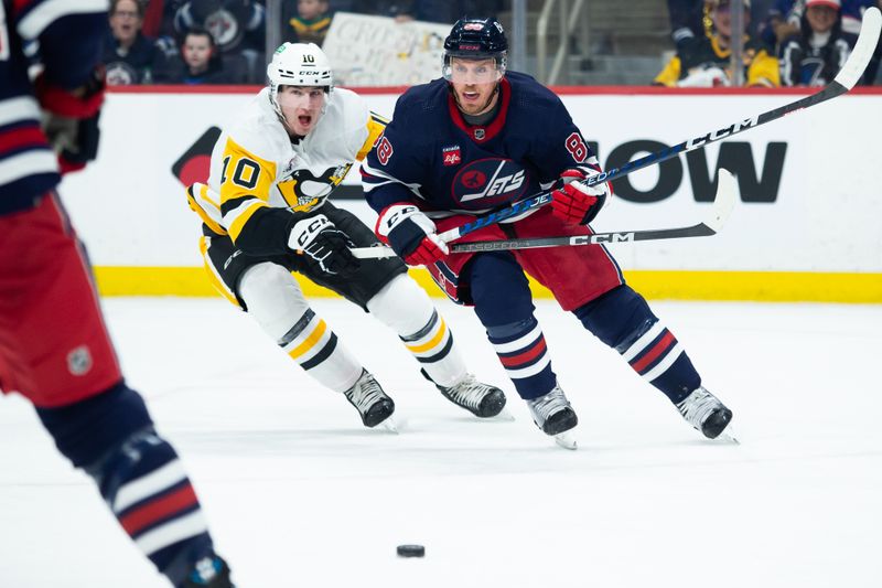 Feb 10, 2024; Winnipeg, Manitoba, CAN;  Winnipeg Jets defenseman Nate Schmidt (88) and Pittsburgh Penguins forward Drew O'Connor (10) skate after the puck during the first period at Canada Life Centre. Mandatory Credit: Terrence Lee-USA TODAY Sports