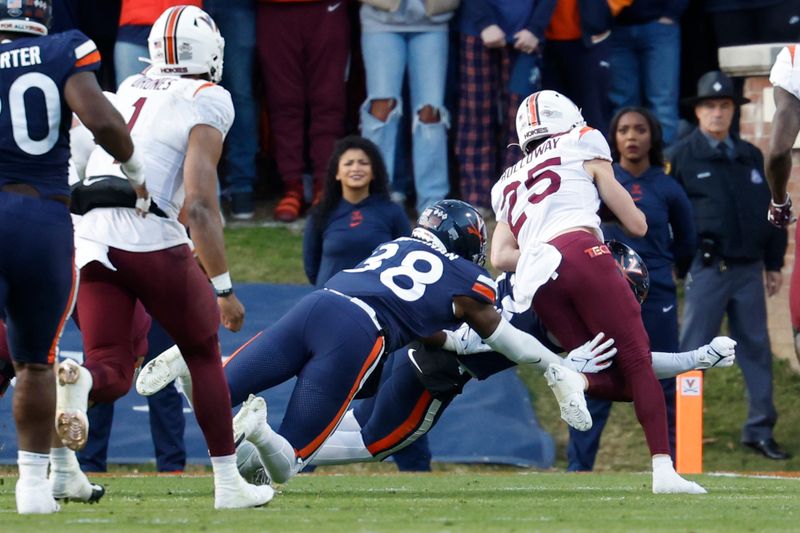 Nov 25, 2023; Charlottesville, Virginia, USA; Virginia Tech Hokies wide receiver Tucker Holloway (25) scores a touchdown as Virginia Cavaliers defensive end Mekhi Buchanan (38) chases during the second quarter at Scott Stadium. Mandatory Credit: Geoff Burke-USA TODAY Sports