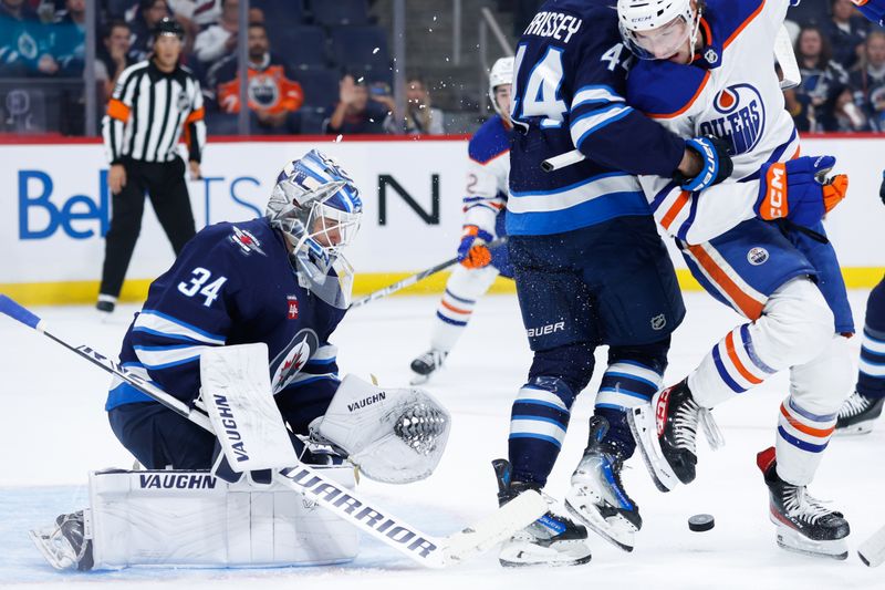 Sep 25, 2024; Winnipeg, Manitoba, CAN; Edmonton Oilers goalie Tyler Parks (40) and Winnipeg Jets goalie Kaapo Kahkonen (34) makes a save as Edmonton Oilers goalie Tyler Parks (40) looks for a rebound during the first period at Canada Life Centre. Mandatory Credit: Terrence Lee-Imagn Images