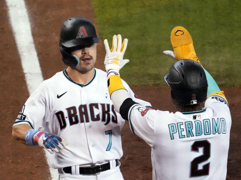 Jun 18, 2023; Phoenix, Arizona, USA; Arizona Diamondbacks center fielder Corbin Carroll (7) and Arizona Diamondbacks shortstop Geraldo Perdomo (2) slap hands after scoring runs against the Cleveland Guardians during the fifth inning at Chase Field. Mandatory Credit: Joe Camporeale-USA TODAY Sports