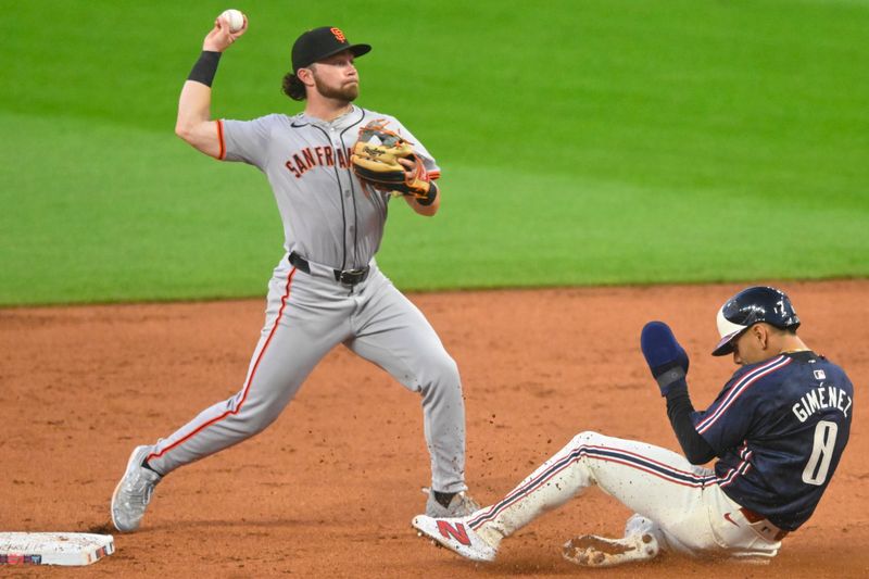 Jul 5, 2024; Cleveland, Ohio, USA; San Francisco Giants second baseman Brett Wisely (0) turns a double play beside Cleveland Guardians second baseman Andres Gimenez (0) in the fourth inning at Progressive Field. Mandatory Credit: David Richard-USA TODAY Sports