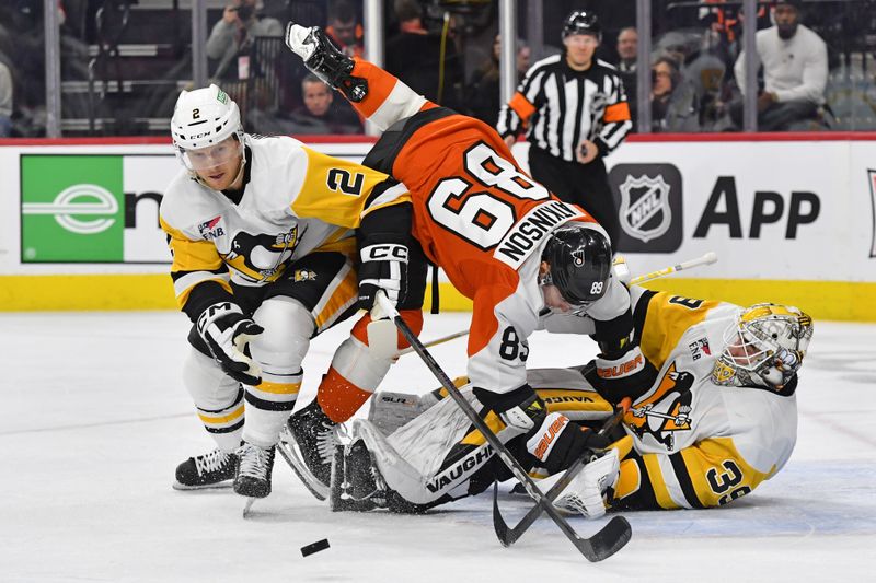 Jan 8, 2024; Philadelphia, Pennsylvania, USA; Pittsburgh Penguins defenseman Chad Ruhwedel (2) reaches for the puck as Philadelphia Flyers right wing Cam Atkinson (89) runs into goaltender Tristan Jarry (35) during the first period at Wells Fargo Center. Mandatory Credit: Eric Hartline-USA TODAY Sports