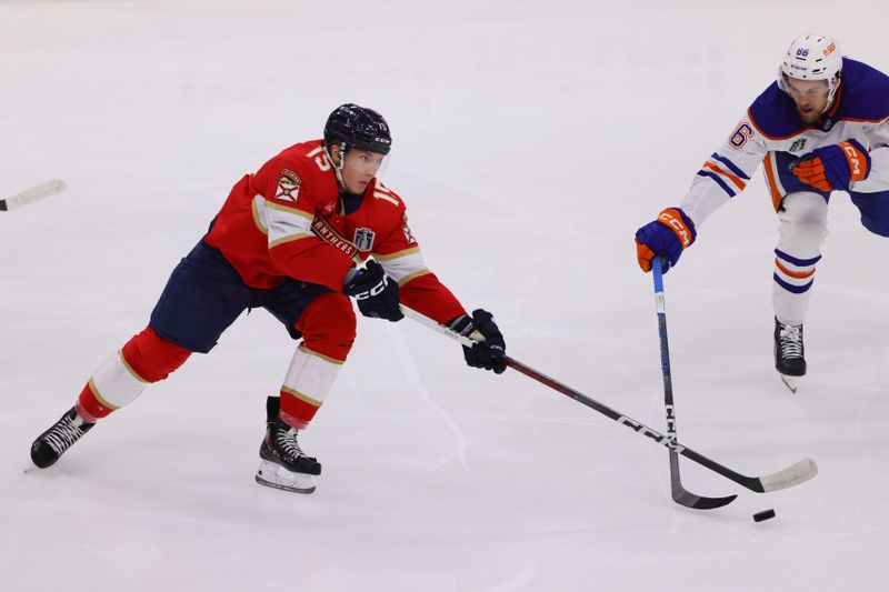 Jun 24, 2024; Sunrise, Florida, USA;  Florida Panthers forward Anton Lundell (15) and Edmonton Oilers defenseman Philip Broberg (86) reach for the puck during the second period in game seven of the 2024 Stanley Cup Final at Amerant Bank Arena. Mandatory Credit: Sam Navarro-USA TODAY Sports