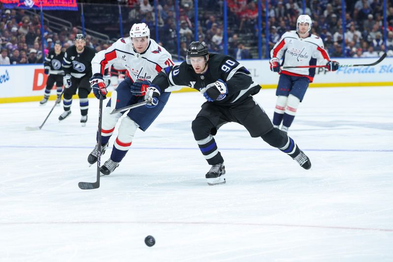 Nov 8, 2025; Tampa, Florida, USA; Washington Capitals center Aliaksei Protas (21) and Tampa Bay Lightning defenseman J.J. Moser (90) battle for the puck in the second period at Benchmark International Arena. Mandatory Credit: Nathan Ray Seebeck-Imagn Images
