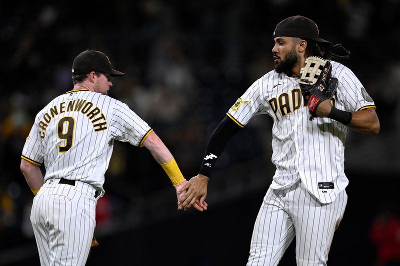 Aug 21, 2023; San Diego, California, USA; San Diego Padres first baseman Jake Cronenworth (9) and right fielder Fernando Tatis (23) celebrate after defeating the Miami Marlins at Petco Park. Mandatory Credit: Orlando Ramirez-USA TODAY Sports