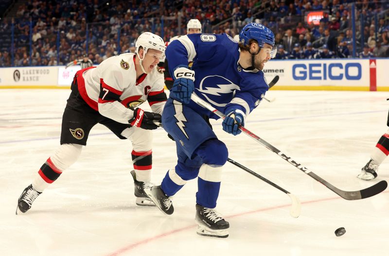 Apr 11, 2024; Tampa, Florida, USA; Tampa Bay Lightning left wing Brandon Hagel (38) skates with the puck as Ottawa Senators left wing Brady Tkachuk (7) defends during the first period at Amalie Arena. Mandatory Credit: Kim Klement Neitzel-USA TODAY Sports