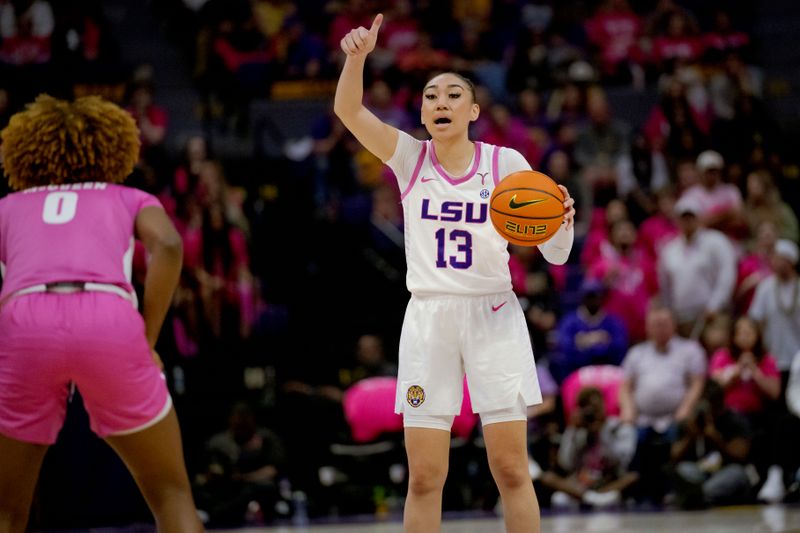 Feb 11, 2024; Baton Rouge, Louisiana, USA;  LSU Lady Tigers guard Last-Tear Poa (13) reacts against  Alabama Crimson Tide guard Loyal McQueen (0) during the second half at Pete Maravich Assembly Center. Mandatory Credit: Matthew Hinton-USA TODAY Sports