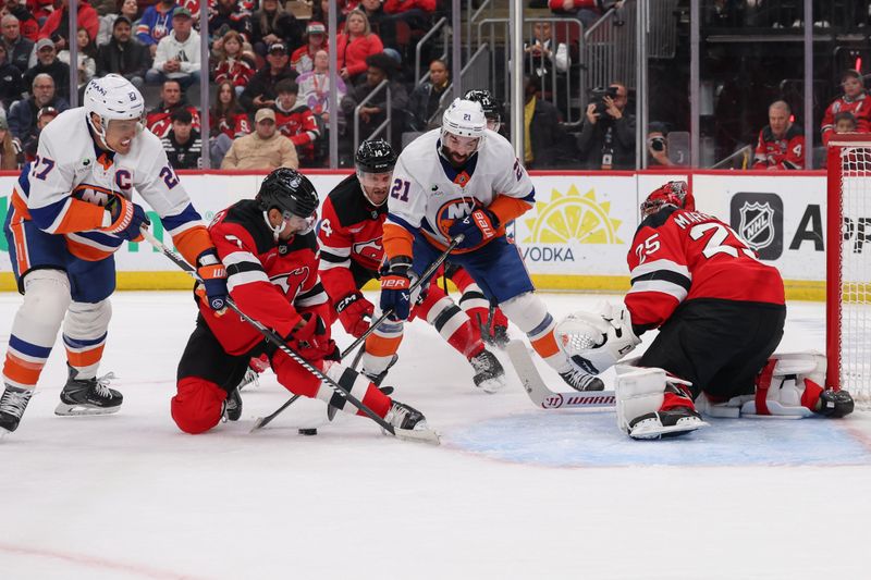 Nov 10, 2025; Newark, New Jersey, USA; New York Islanders center Kyle Palmieri (21) and New Jersey Devils defenseman Jonas Siegenthaler (71) battle for the puck in front of New Jersey Devils goaltender Jacob Markstrom (25) during the first period at Prudential Center. Mandatory Credit: Ed Mulholland-Imagn Images